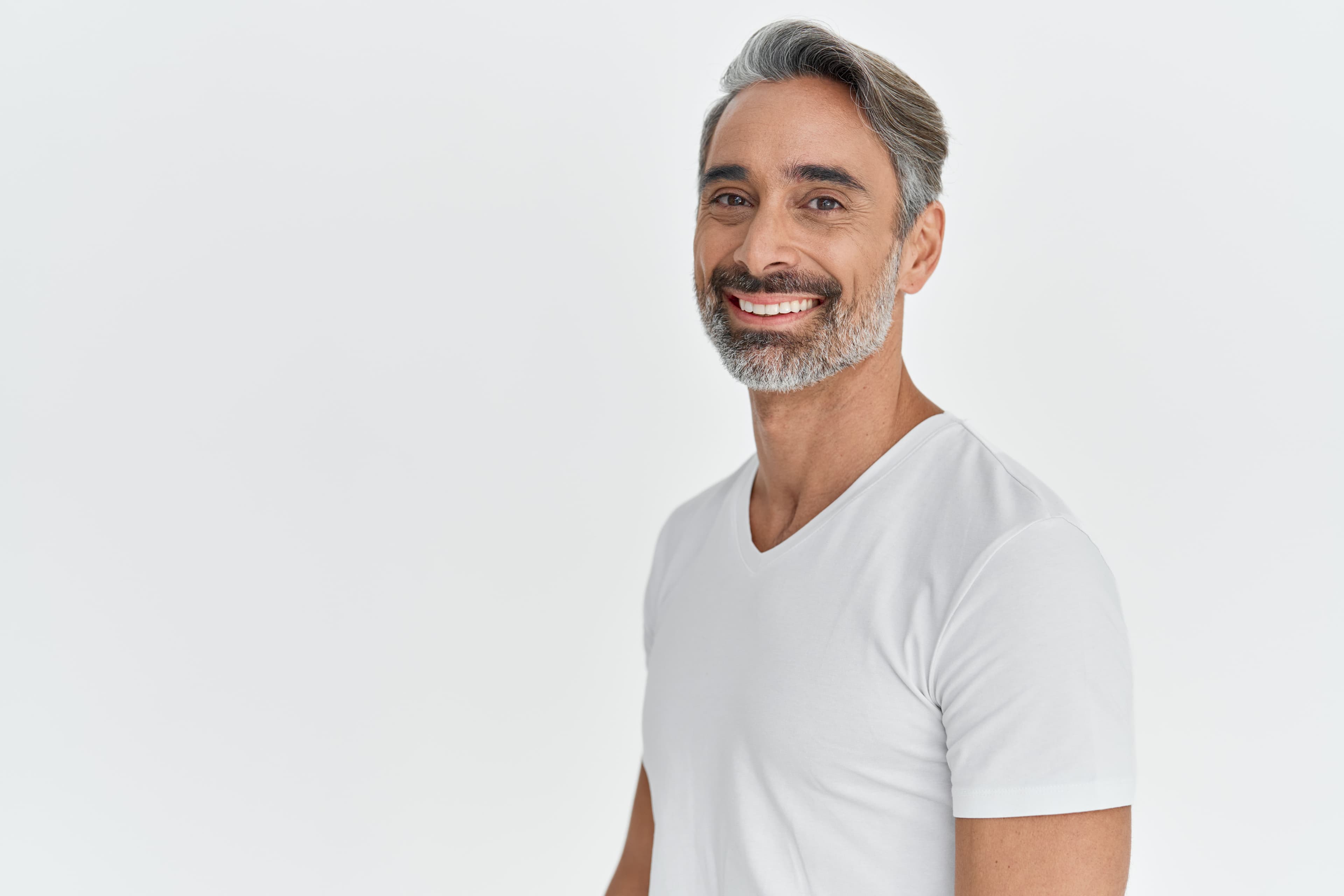 Confident mature man with natural-looking hair transplant results showing salt-and-pepper hair